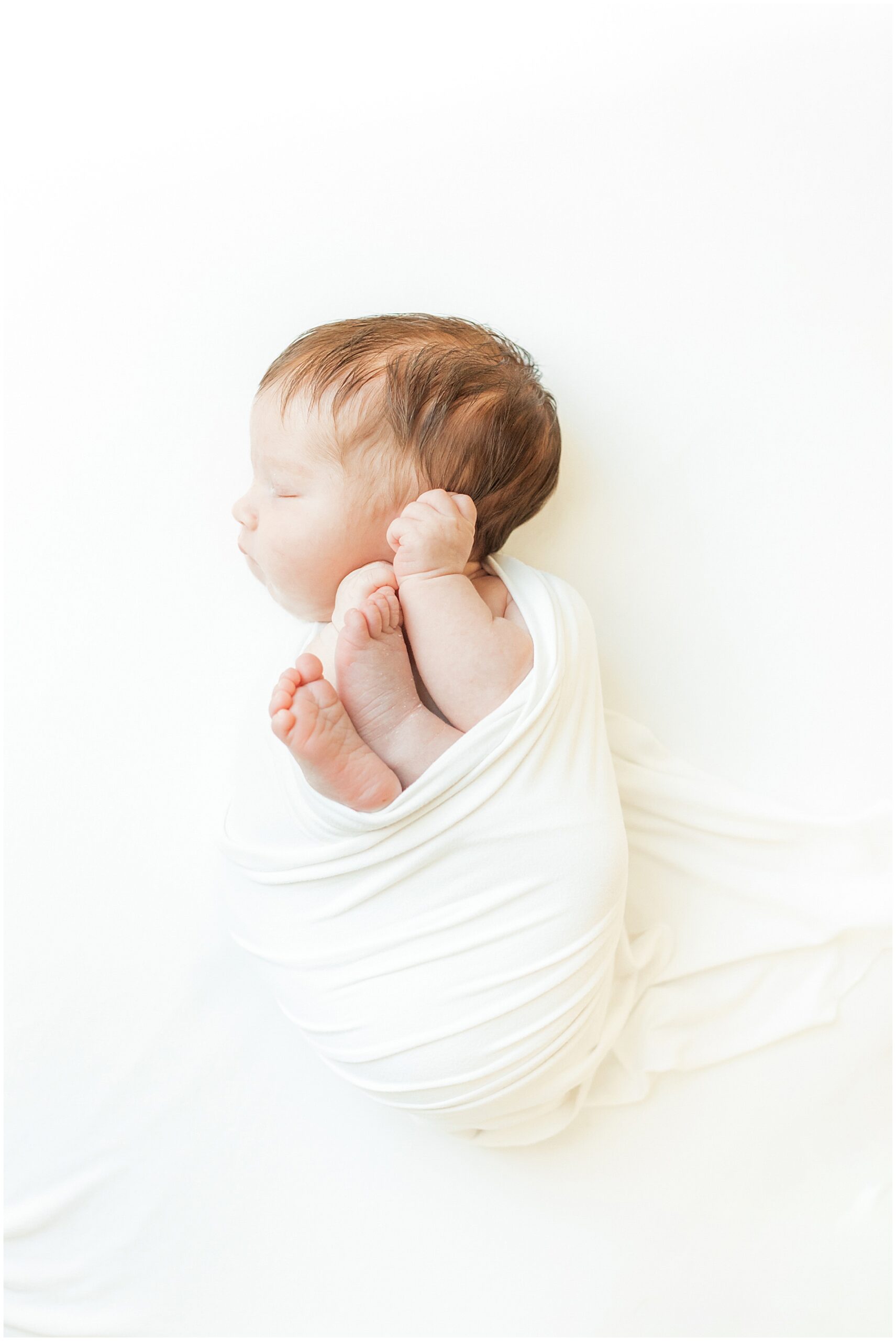newborn baby girl wrapped in white cloth