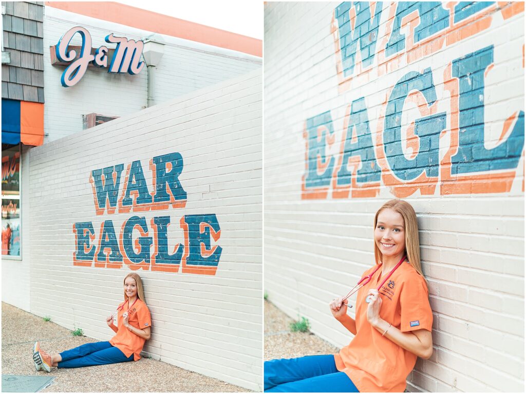 nursing grad wearing scrubs at war eagle wall auburn university